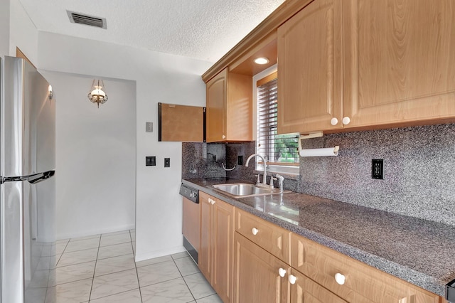 kitchen featuring marble finish floor, visible vents, freestanding refrigerator, a sink, and a textured ceiling