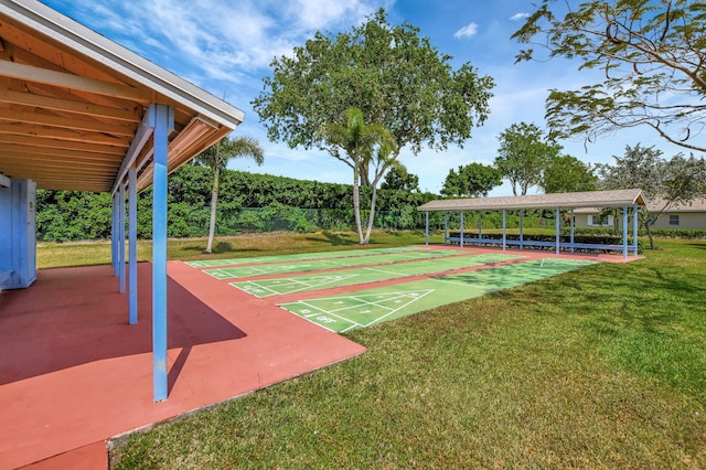 view of home's community with a lawn and shuffleboard