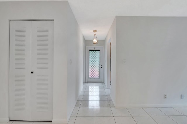 doorway with baseboards and light tile patterned flooring