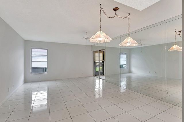 empty room featuring a healthy amount of sunlight and light tile patterned floors