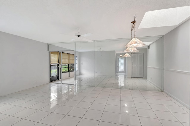 unfurnished room with ceiling fan and light tile patterned floors