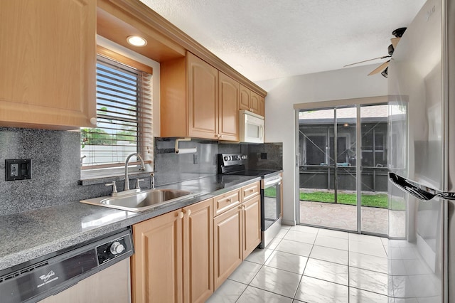 kitchen featuring decorative backsplash, ceiling fan, appliances with stainless steel finishes, a textured ceiling, and a sink