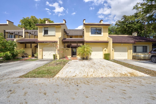 townhome / multi-family property featuring driveway, an attached garage, and stucco siding