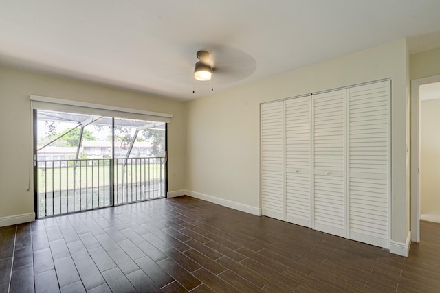 interior space with dark wood finished floors, a ceiling fan, and baseboards