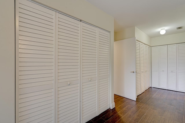 hall featuring visible vents and dark wood finished floors