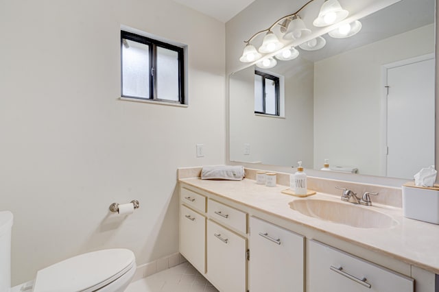 half bath featuring toilet, tile patterned floors, baseboards, and vanity