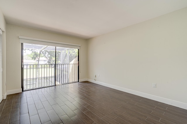 unfurnished room featuring dark wood-style flooring and baseboards