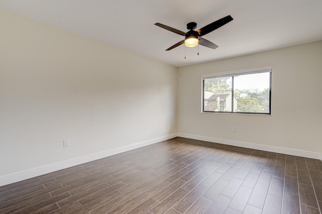 empty room featuring ceiling fan, baseboards, and dark wood-type flooring