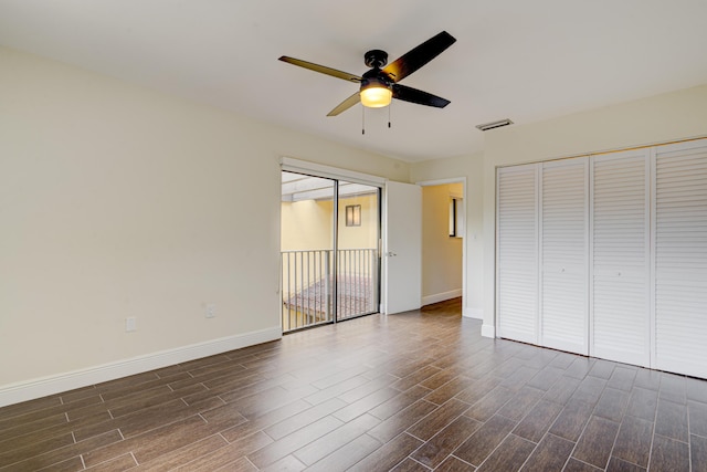 unfurnished bedroom featuring ceiling fan, dark wood-style flooring, visible vents, and baseboards