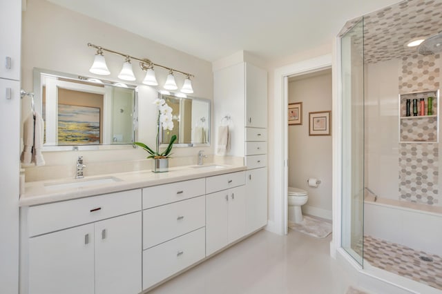 bathroom with a sink, a shower stall, toilet, and double vanity