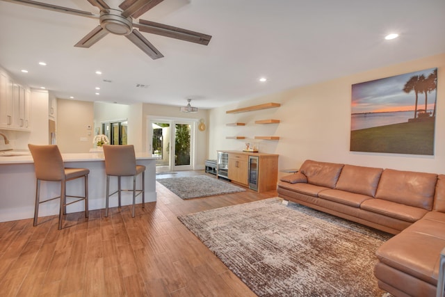 living room featuring light wood-style flooring, ceiling fan, and recessed lighting