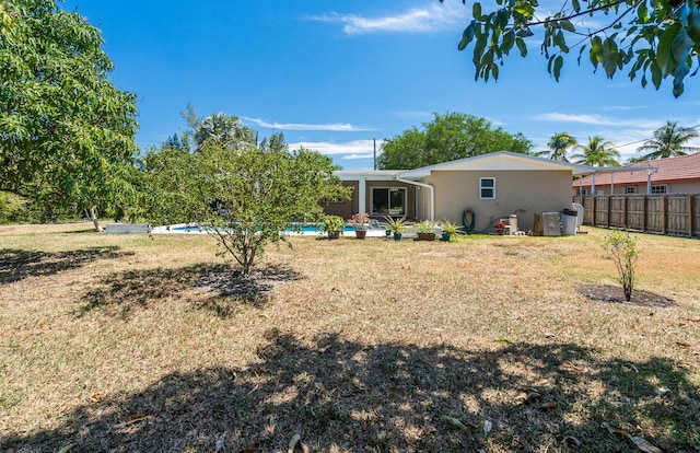 17400 SW 92nd Ct, Palmetto Bay, FL 33157 - back of house with a patio area, a fenced in pool, stucco siding, fence, and a lawn