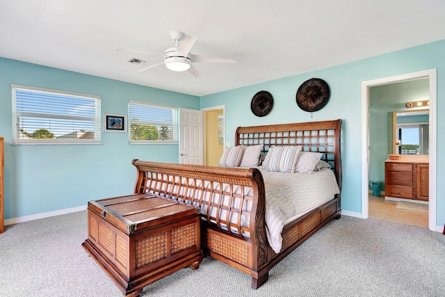 carpeted bedroom with a ceiling fan, visible vents, baseboards, and ensuite bathroom