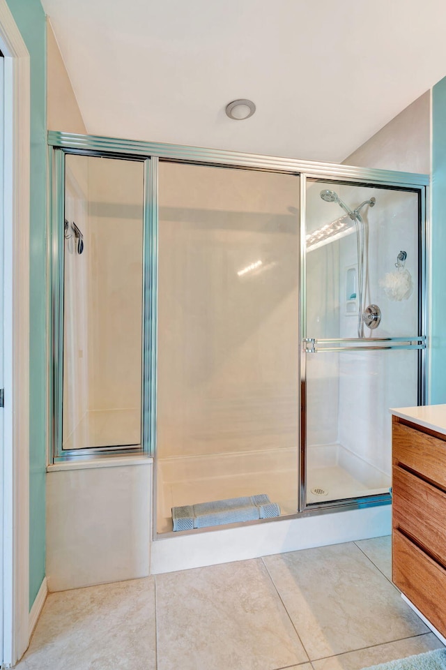 full bathroom featuring vanity, tile patterned flooring, and a shower with shower door