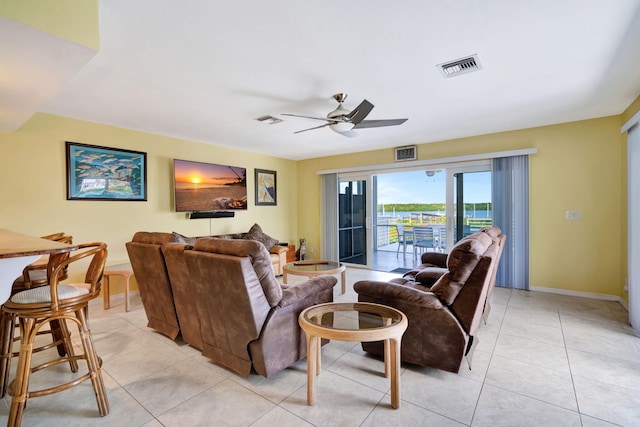 living room with baseboards, visible vents, a ceiling fan, and light tile patterned flooring