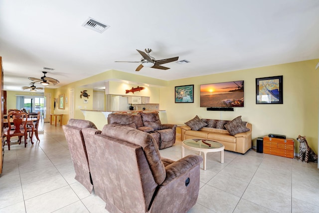 living area with visible vents, ceiling fan, and light tile patterned floors