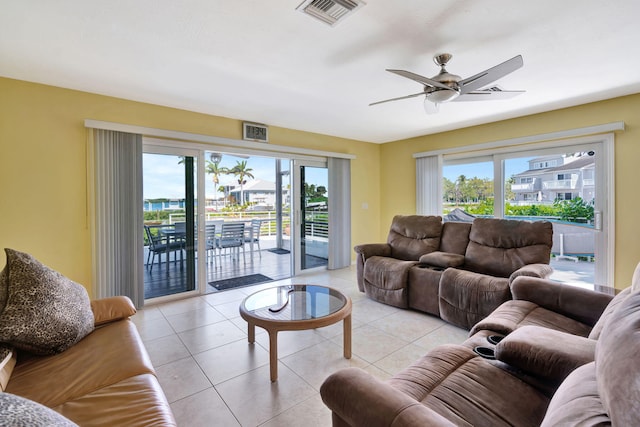 living area featuring a healthy amount of sunlight, visible vents, a ceiling fan, and light tile patterned flooring