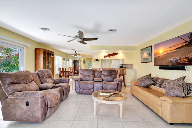 living area featuring light tile patterned floors, ceiling fan, and visible vents