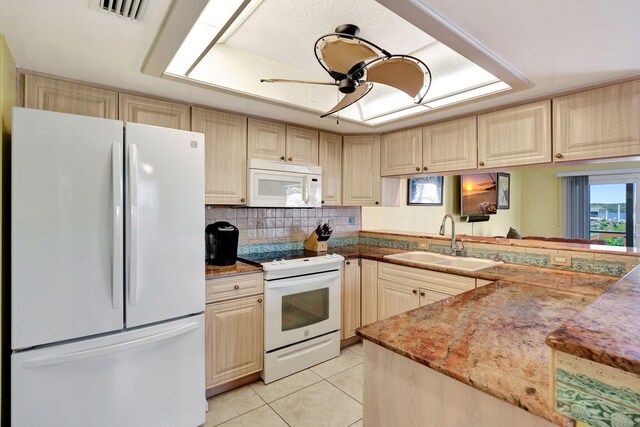 kitchen featuring light tile patterned floors, tasteful backsplash, visible vents, a sink, and white appliances