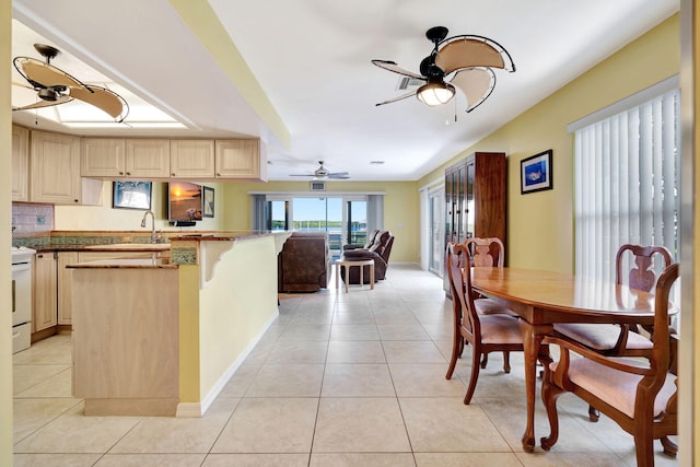 dining room featuring a ceiling fan, baseboards, and light tile patterned floors