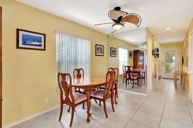 dining space featuring light tile patterned floors, ceiling fan, and baseboards