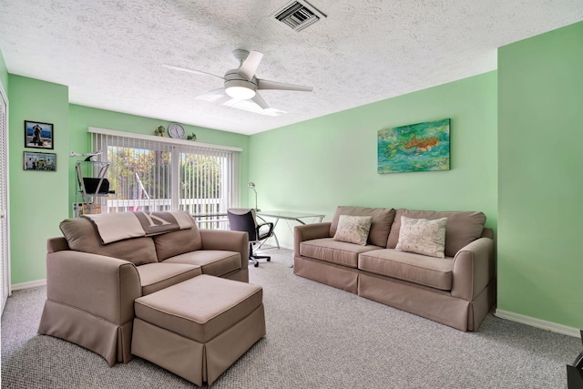 carpeted living room featuring visible vents, ceiling fan, a textured ceiling, and baseboards