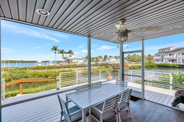 sunroom with a wealth of natural light, a water view, and ceiling fan