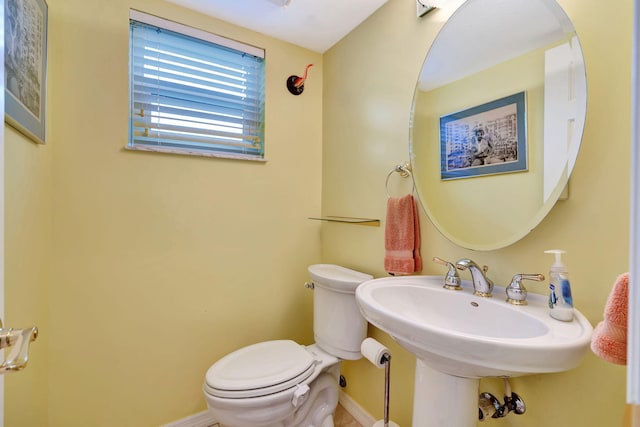 half bath with toilet and baseboards