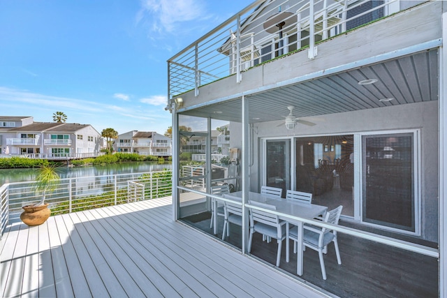 deck featuring a water view, ceiling fan, a residential view, and outdoor dining area