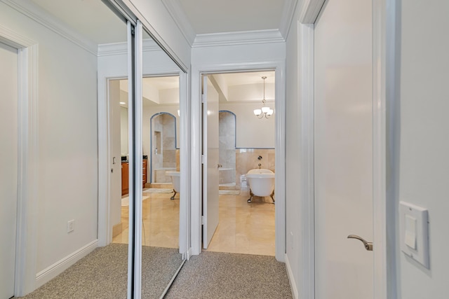 hallway featuring light colored carpet, crown molding, and arched walkways