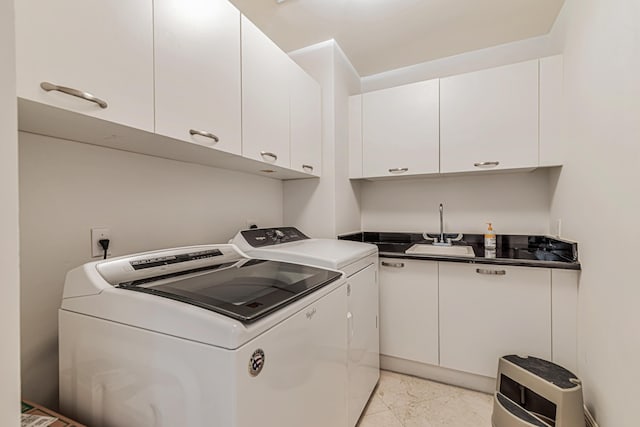 clothes washing area with marble finish floor, washing machine and clothes dryer, a sink, and cabinet space