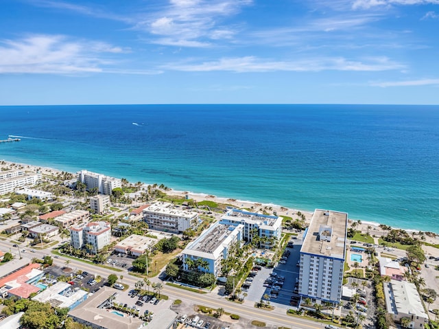 birds eye view of property with a water view, a beach view, and a city view