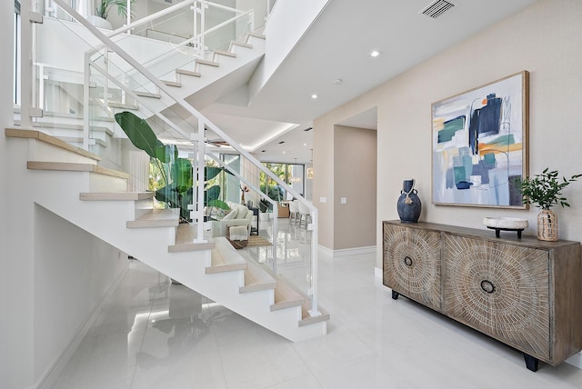 stairs with recessed lighting, visible vents, and baseboards