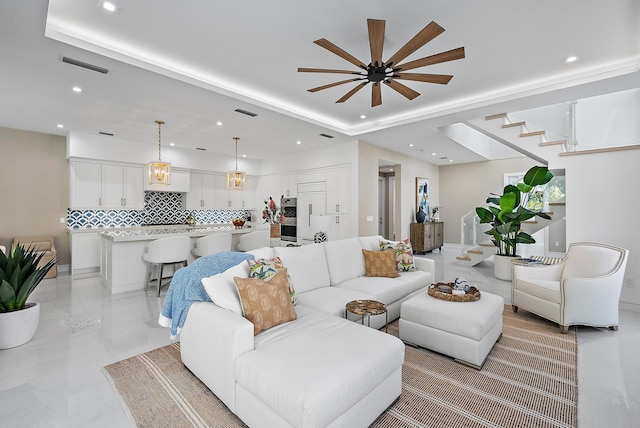 living area with stairs, visible vents, a raised ceiling, and recessed lighting