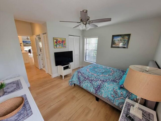 bedroom featuring light wood-style floors, ceiling fan, and two closets