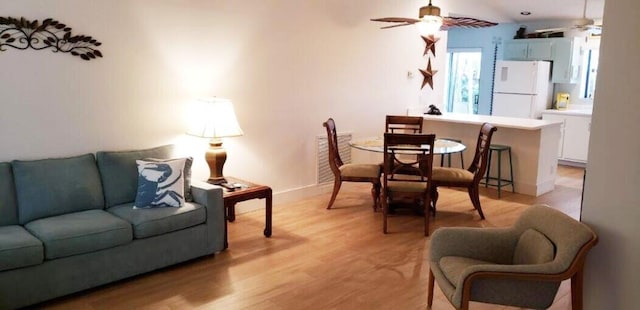 living room featuring a ceiling fan, light wood-style flooring, and baseboards