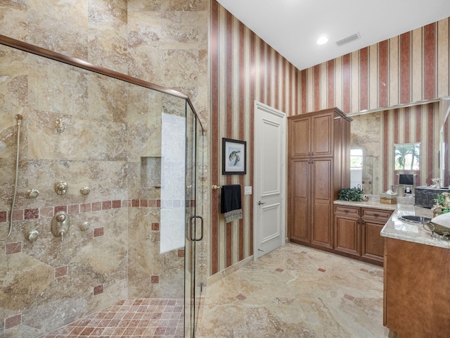 bathroom featuring a stall shower, visible vents, vanity, and wallpapered walls