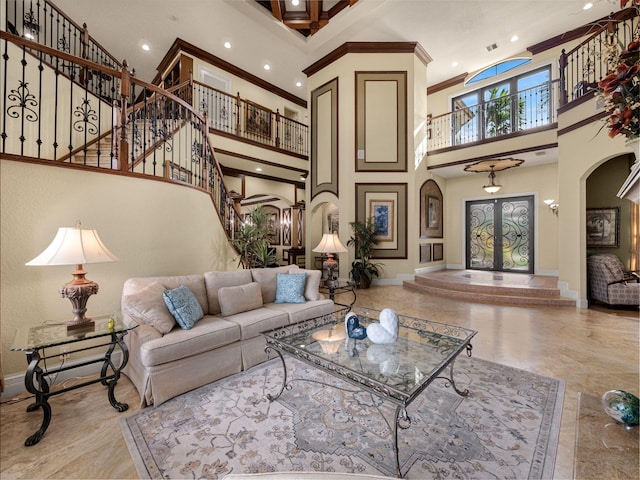 living room with ornamental molding, arched walkways, baseboards, and stairs