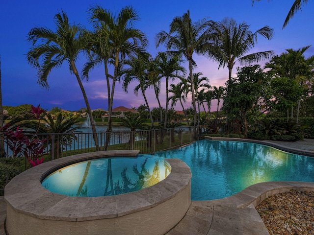 pool at dusk with fence and a fenced in pool