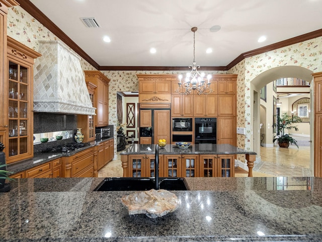 kitchen featuring arched walkways, crown molding, visible vents, black appliances, and wallpapered walls