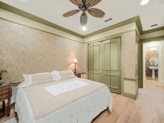 bedroom with crown molding, light wood-style flooring, visible vents, and wallpapered walls