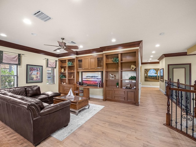 living room with ornamental molding, light wood-type flooring, visible vents, and baseboards