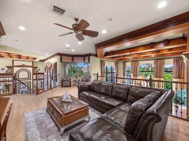 living area featuring recessed lighting, visible vents, a textured ceiling, and wood finished floors