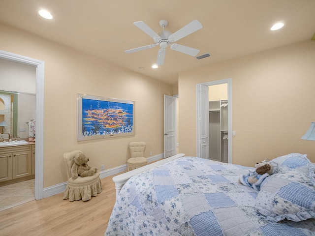 bedroom featuring light wood-type flooring, baseboards, a sink, and recessed lighting