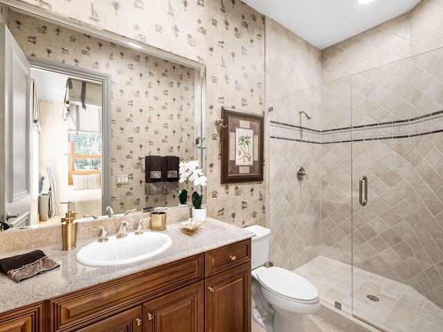 full bathroom featuring vanity, a shower stall, toilet, and wallpapered walls