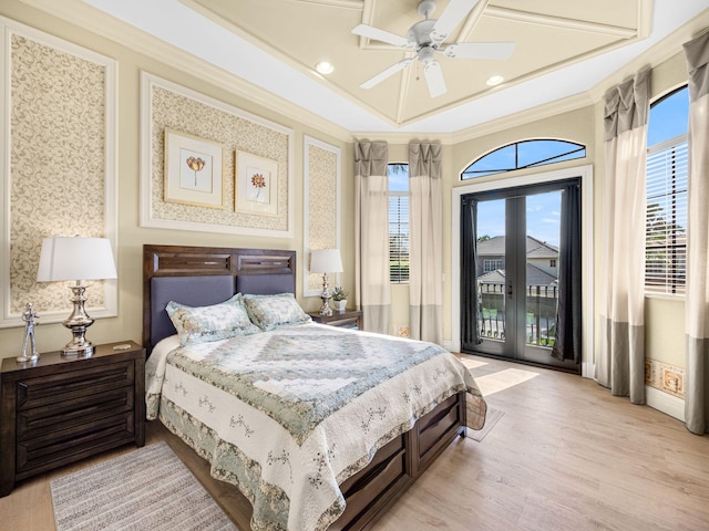 bedroom with ornamental molding, multiple windows, light wood-style flooring, and access to exterior