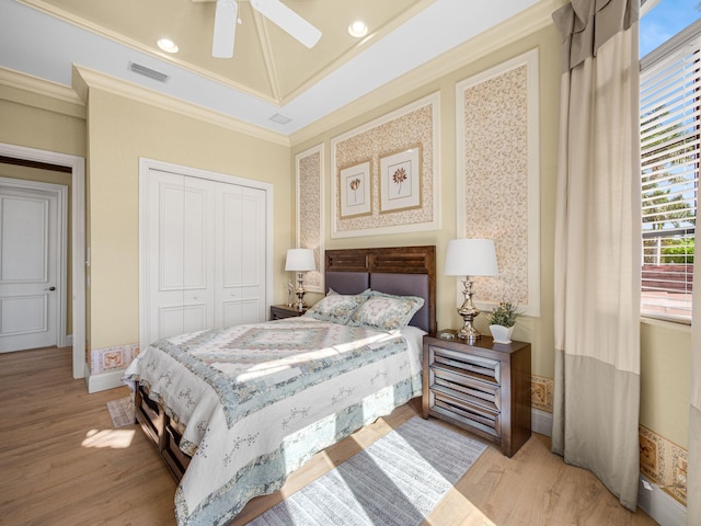 bedroom with ornamental molding, a closet, visible vents, and light wood finished floors