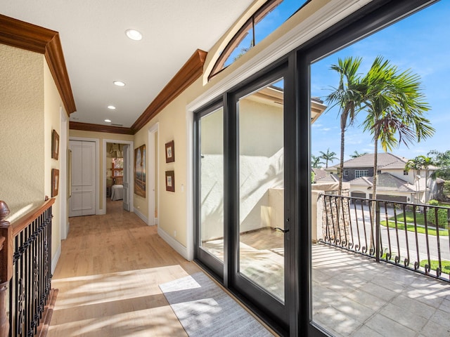 hall featuring baseboards, ornamental molding, plenty of natural light, and recessed lighting