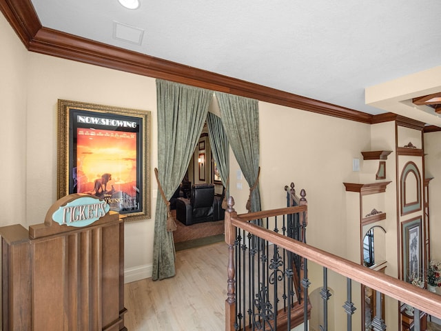 corridor with crown molding, visible vents, an upstairs landing, wood finished floors, and baseboards