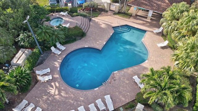 community pool with a community hot tub, a patio area, and fence